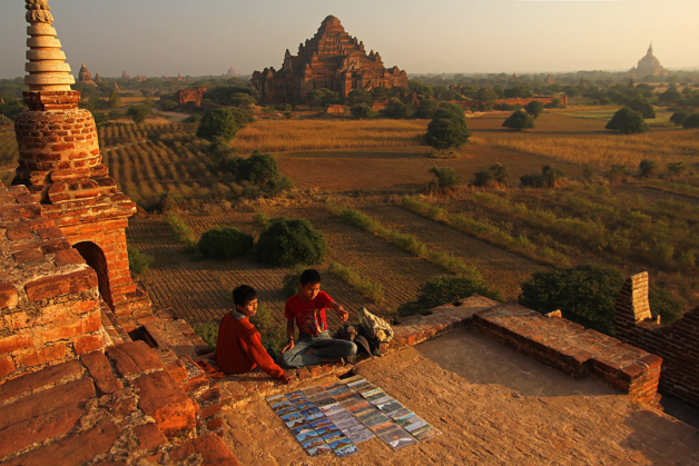 Myanmar two boys sell postcards on a pagoda at Bagan