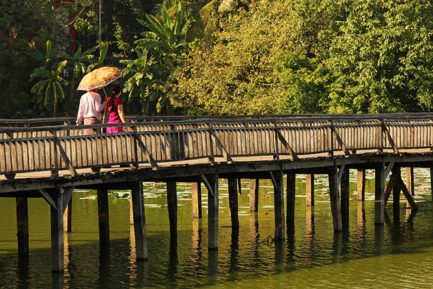 Myanmar a couple walks across a bridge in Kandawgyi park, Yangon