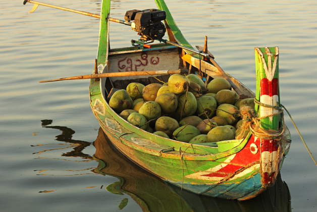 Myanmar traditional boat with coconuts in river near U Bein Bridge