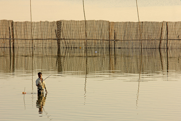 Myanmar fisherman in river near U Bein Bridge